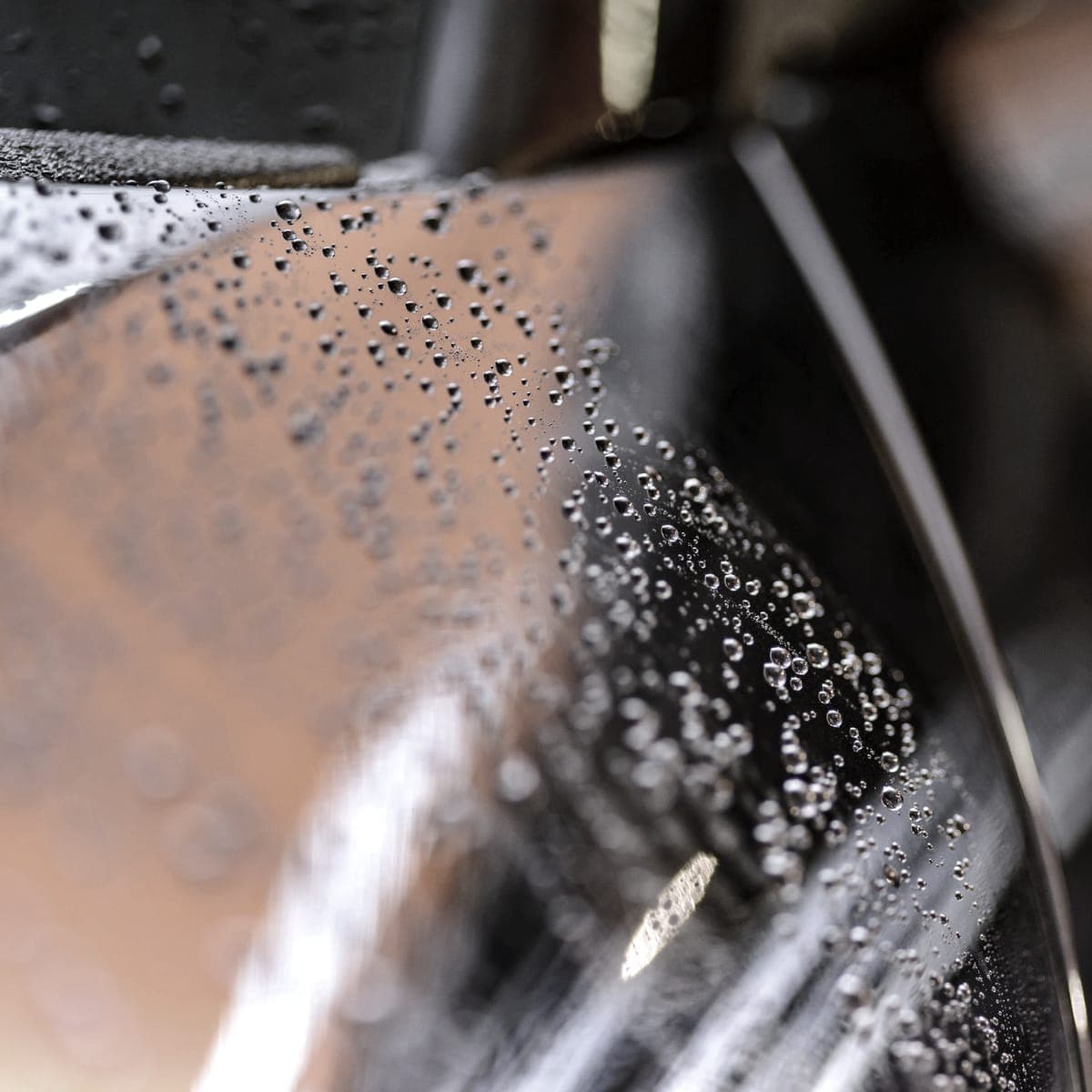 Water standing in tight beads on a glossy panel